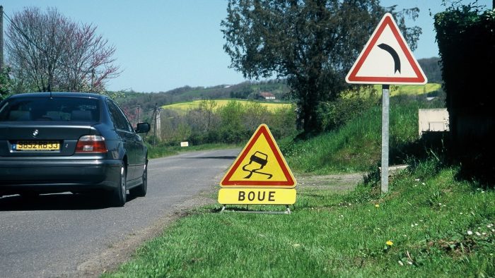 Panneau de signalisation route glissante avec présence de boue